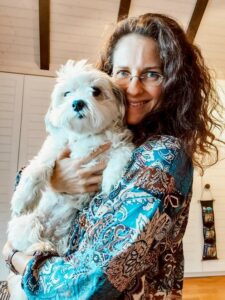 Eine Frau mit einem kleinen weißen Hund im Arm